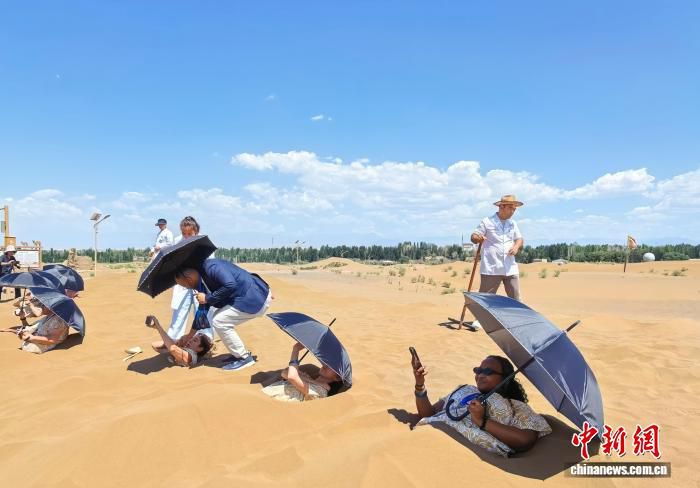新疆吐鲁番气温逼近40℃ 上海游客体验沙漠沙疗